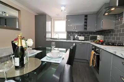 a kitchen with a table with a bottle of champagne at Signature - Kirkhill Lower in Kirkmuirhill