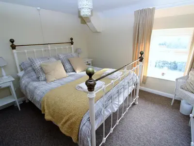 a bedroom with a white bed and a window at 2 Mellfell View in Penrith