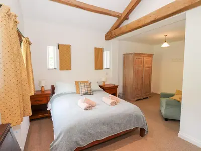 a bedroom with a bed with two pink towels on it at Two Town End in Penrith