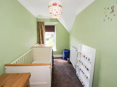 a childs room with a crib and a refrigerator at Oakhurst in Keswick