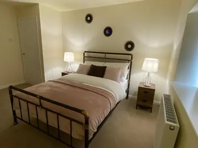 a bedroom with a bed with two lamps on it at Rattlebeck Farm Cottage and Hot Tub PET FRIENDLY in Welton
