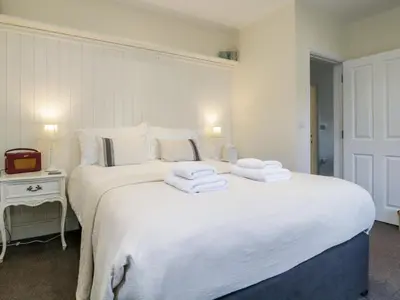 a bedroom with a large white bed with towels on it at The Bakers Loft in Ambleside