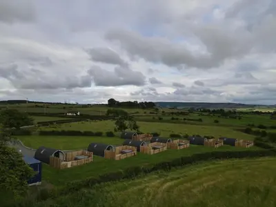 a group of hay bales in a field at Timber Valley Pods in Galston