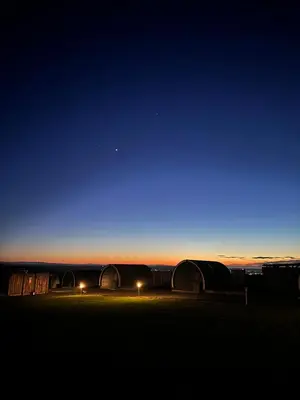 a night sky with two domes in a field at Timber Valley Pods in Galston