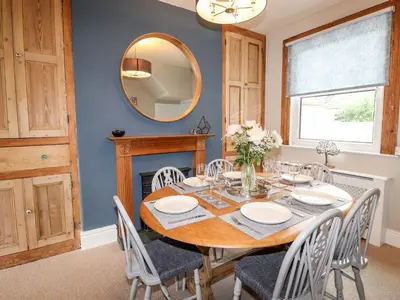 a dining room with a table and chairs and a mirror at Stanegarth in Keswick
