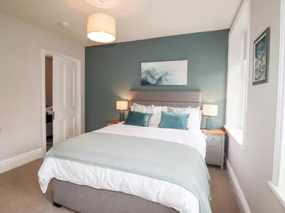 a bedroom with a large bed with blue walls at Stanegarth in Keswick