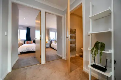 a room with a bedroom with a bed and a mirror at Troon Executive Apartment in Troon
