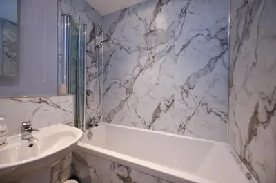 a bathroom with a white tub and a sink at Troon Executive Apartment in Troon