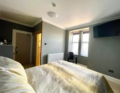 a bedroom with a large bed and a window at Number 53 in Girvan