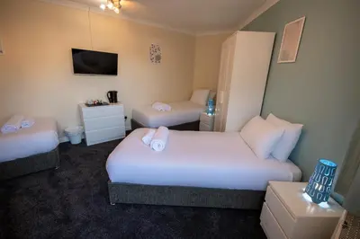 a hotel room with two beds and a tv at Irvine Riverside Guesthouse in Irvine