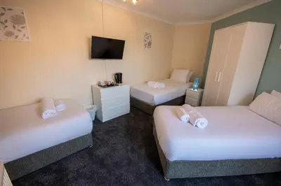 a hotel room with two beds and a tv at Irvine Riverside Guesthouse in Irvine