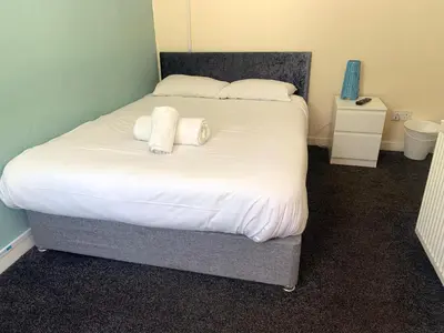 a bed with two white towels on top of it at Irvine Riverside Guesthouse in Irvine