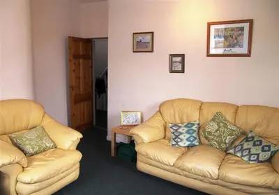 a living room with two leather couches and a table at 26 Castle Street in Kirkcudbright
