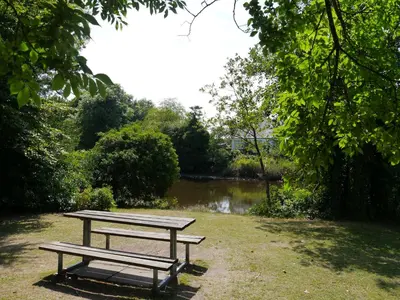 a picnic table in a park next to a river at Bar Hill Lodge in Gatehouse of Fleet