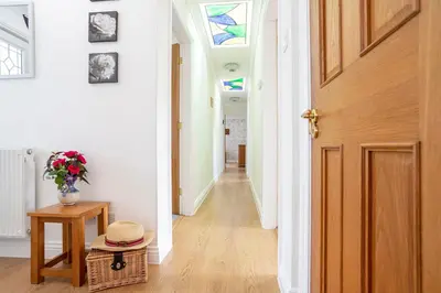 a hallway with a door and a hat on a table at Finest Retreats - The Duck House in Braithwaite