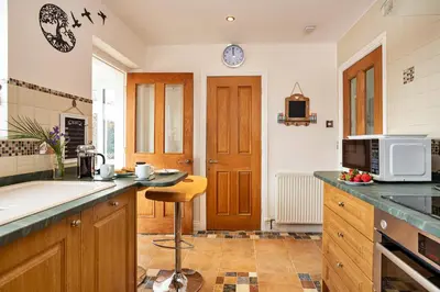 a kitchen with wooden cabinets and a counter top at Finest Retreats - The Duck House in Braithwaite