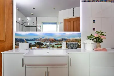 a white kitchen with a sink and a painting on the wall at Finest Retreats - The Duck House in Braithwaite