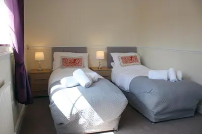 two beds in a room with two lamps on them at Carvetii - Uriah House - 4-Bedroom House sleeps up to 10 people in Belle Vue