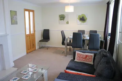 a living room with a table and a couch at Carvetii - Uriah House - 4-Bedroom House sleeps up to 10 people in Belle Vue