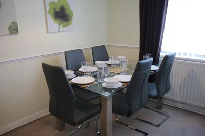 a dining room table with black chairs and a table and a table and chairsktop at Carvetii - Uriah House - 4-Bedroom House sleeps up to 10 people in Belle Vue