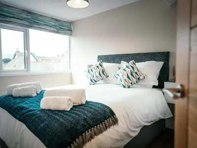 a bedroom with a large bed with towels on it at The Deekabout in Keswick