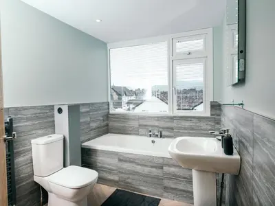 a bathroom with a tub and a toilet and a sink at The Deekabout in Keswick