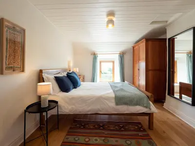 a bedroom with a bed with blue pillows and a window at Wayside Cottage 1637 in Millom