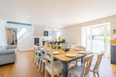 a dining room and kitchen with a table and chairs at Nether Newton - Sleeps 12, Hottub, Sauna, Private Garden in Newmilns