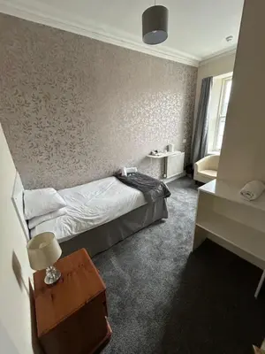 a hotel room with a bed and a table at The Maxwell Arms Hotel in Dalbeattie