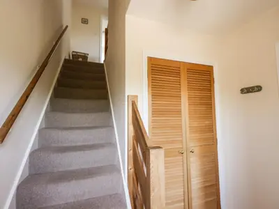 a staircase with a wooden door next to a stair case at Wood End in Dalbeattie