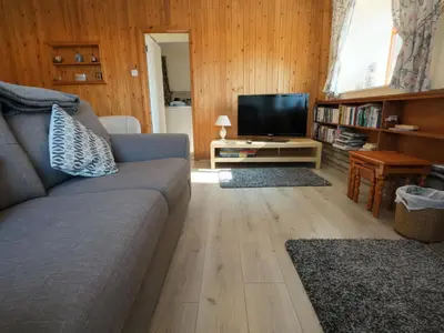a living room with a couch and a flat screen tv at Wood End in Dalbeattie