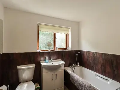 a bathroom with a toilet and a sink and a bath tub at Wood End in Dalbeattie
