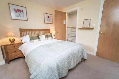 a bedroom with a bed and a night stand with a lamp at 11 Howrah's Court in Keswick