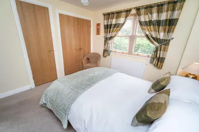 a bedroom with a white bed and a window at 11 Howrah's Court in Keswick