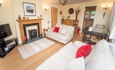 a living room with two white couches and a fireplace at 11 Howrah's Court in Keswick