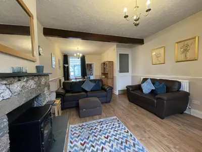 a living room with two couches and a fireplace at Abacourt Cottage in Keswick