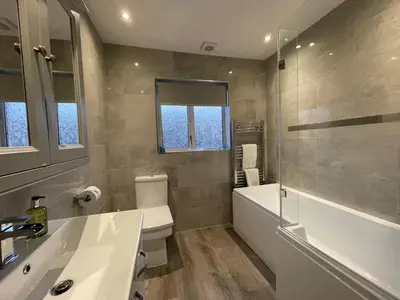 a bathroom with a sink and a tub and a toilet at Abacourt Cottage in Keswick