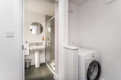 a bathroom with a washing machine and a sink at 3 The Townhouse in Keswick