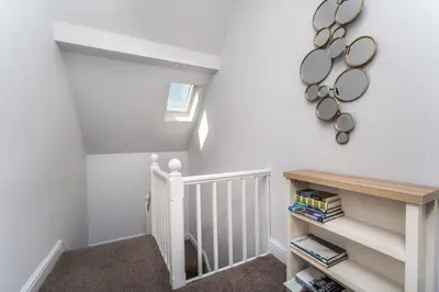 a stairway with white walls and a white stair case at 3 The Townhouse in Keswick