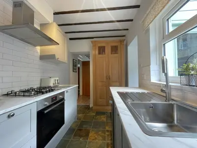a kitchen with a sink and a stove at Acorn Cottage in Keswick