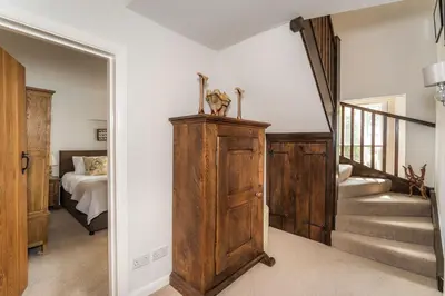 a hallway with a room with a bed and stairs at Acorn Cottage in Keswick