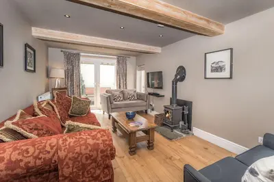 a living room with a couch and a wood stove at 9 The Townhouse in Keswick