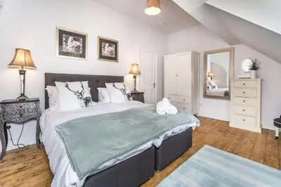 a bedroom with a large bed and a large mirror at 7 The Townhouse in Keswick