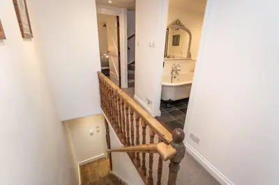 a staircase leading to a bathroom with a sink at Barf Cottage in Portinscale