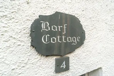 a sign on the side of a building with an umbrella at Barf Cottage in Portinscale