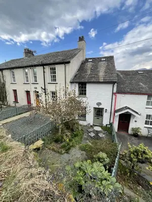 a white house with red doors and a yard at Barf Cottage in Portinscale