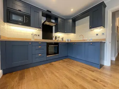 a kitchen with blue cabinets and a wooden floor at Park View in Keswick