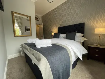 a bedroom with a large bed and a mirror at Park View in Keswick