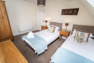 a bedroom with two beds with teddy bears on them at Skiddaw Skies in Keswick