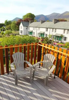 two white chairs sitting on top of a deck at Skiddaw Skies in Keswick